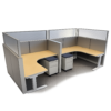 Office cubicles with L-shaped beige desks, gray partition panels, and mobile pedestal drawers between workstations.